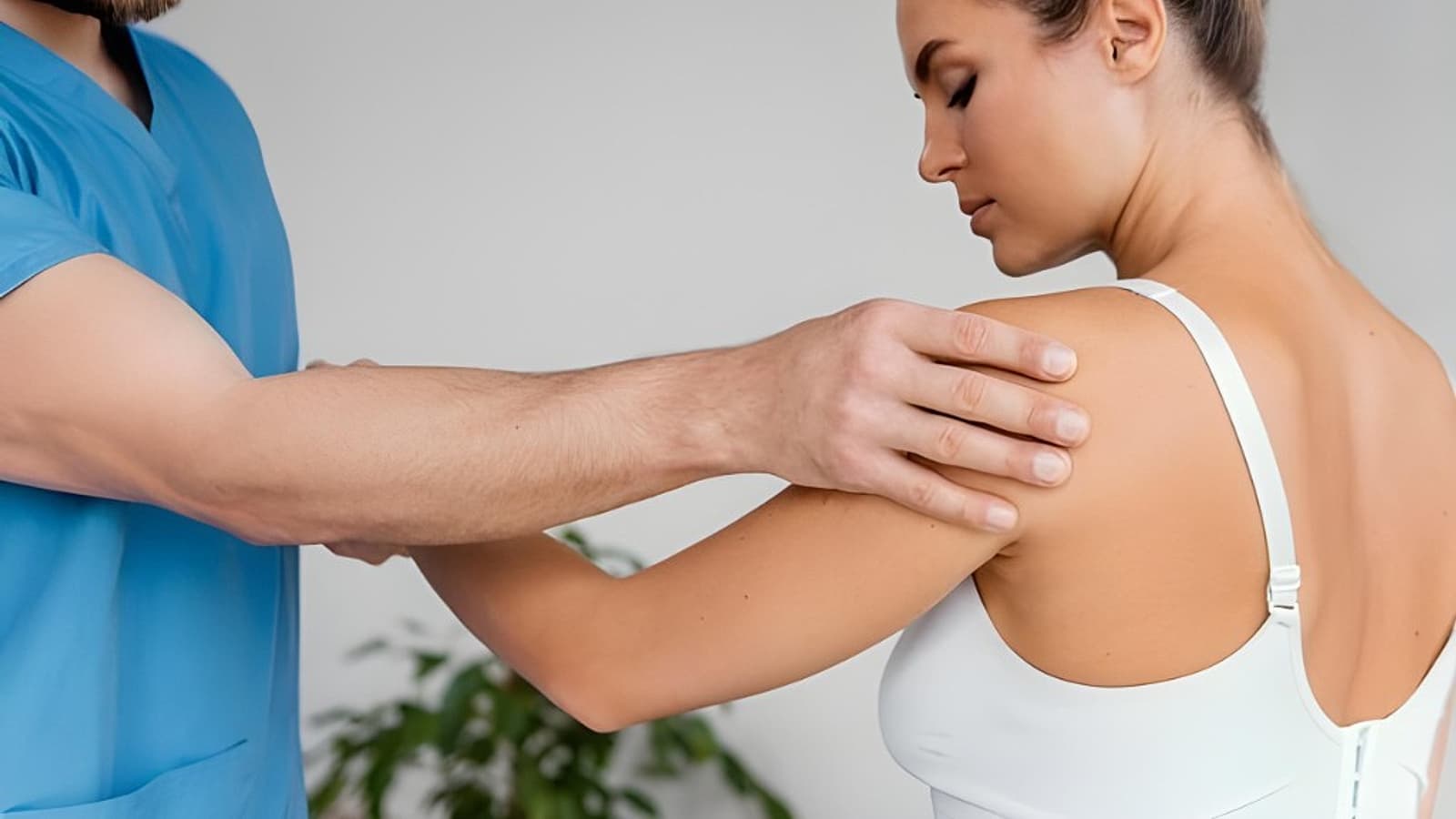 Fysiotherapeut onderzoekt de schouder van een patiënt tijdens een behandeling